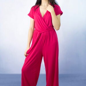 Enterizo fucsia con escote cruzado y pantalón amplio, cinturón en tela a juego.